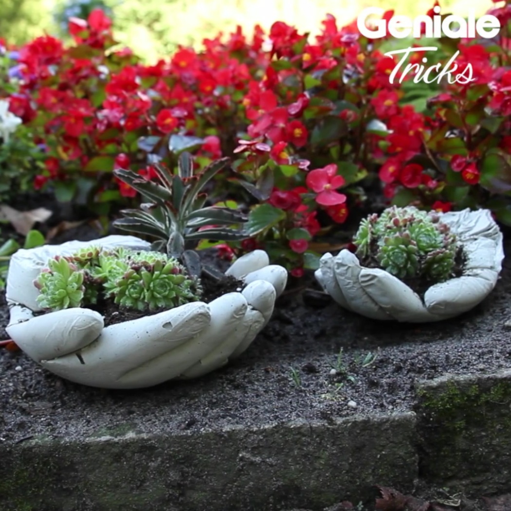 une photo de décoration de jardin en ciment en forme de mains