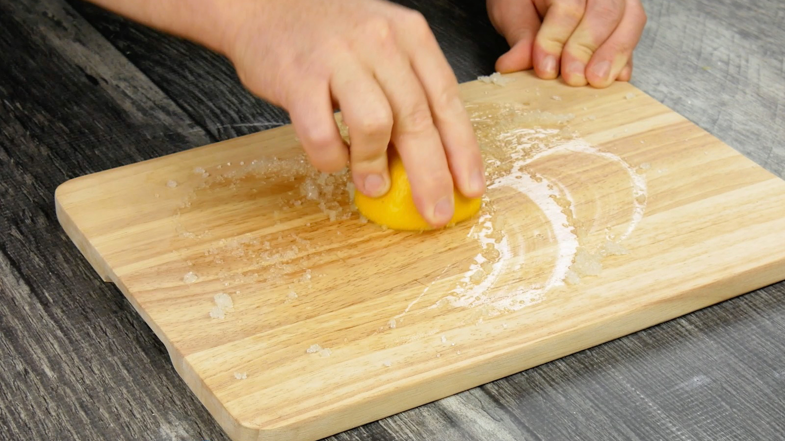 moitié d'un citron avec du sel pour nettoyer et éliminer les odeurs d'une planche à découper en bois