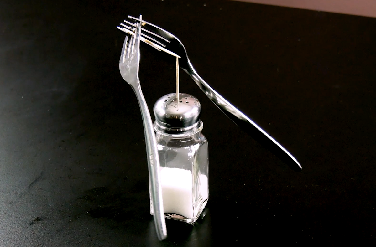 fourchettes sont en équilibre à l'aide des deux cure-dents (dans les fourchettes et dans la salière)