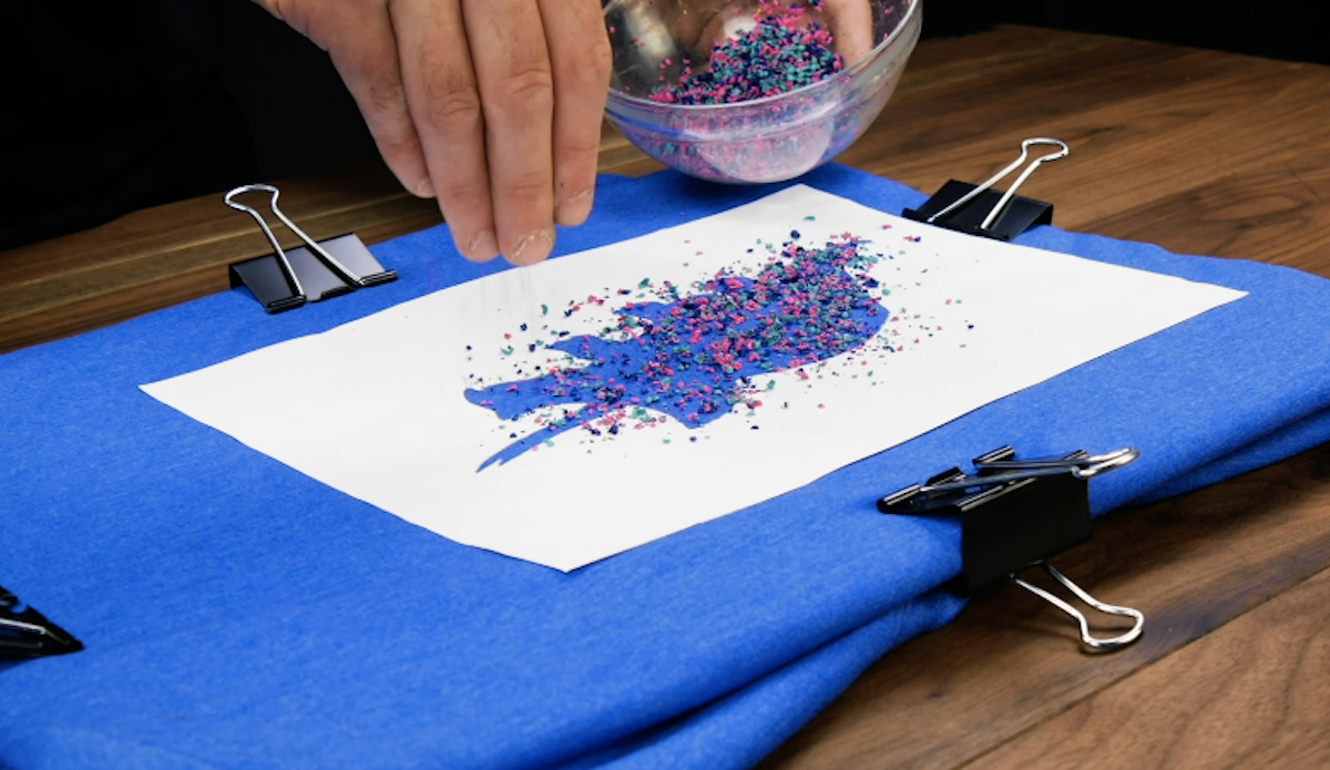 Placez la feuille sans le motif sur le T-shirt et saupoudrez-la avec les crayons de cire râpés.
