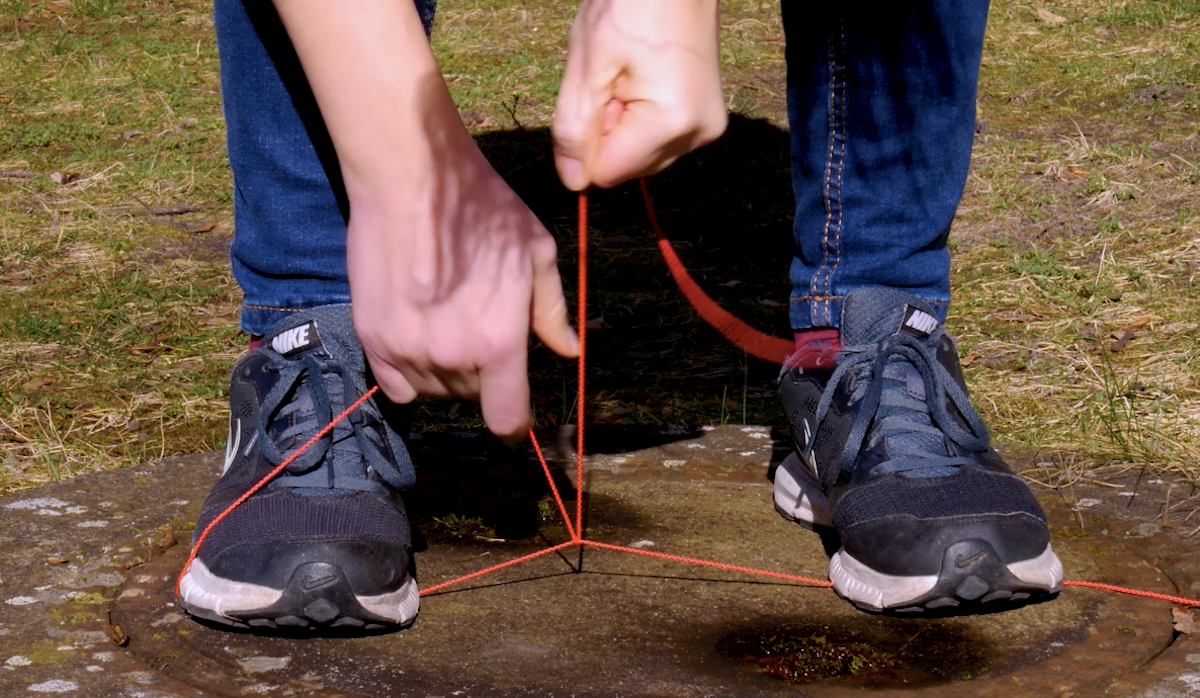 couper une corde en la bloquant entre les pieds et en frottant