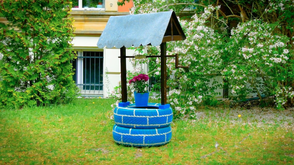 puits fait maison avec des pneus dans le jardin